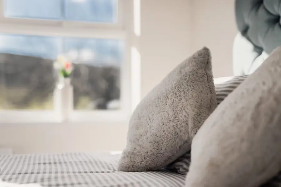 Soft cushions on the bed by the window