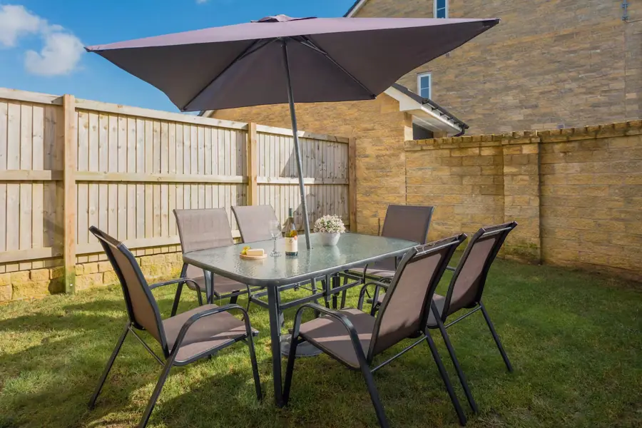 Sunny garden with table, chairs and parasol