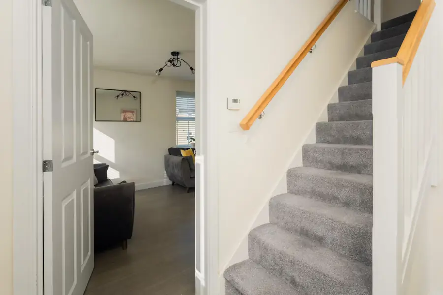 The hall, with the stairs and a view into the sitting room